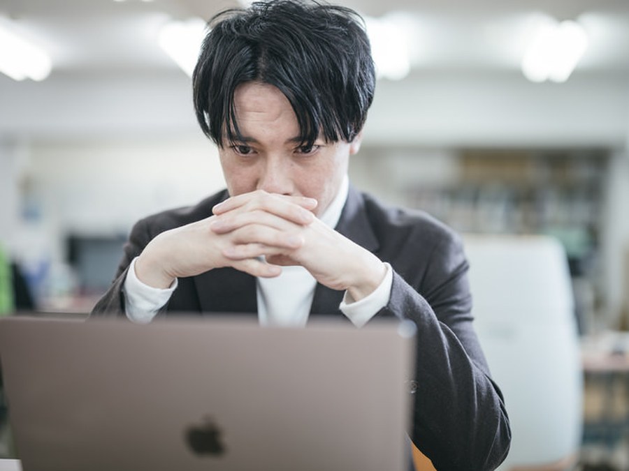 業務に追われて悩んでいる人のイメージ